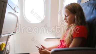 可爱的小女孩坐<strong>飞机</strong>坐在窗边。 <strong>小孩</strong>坐在<strong>飞机</strong>窗前听音乐